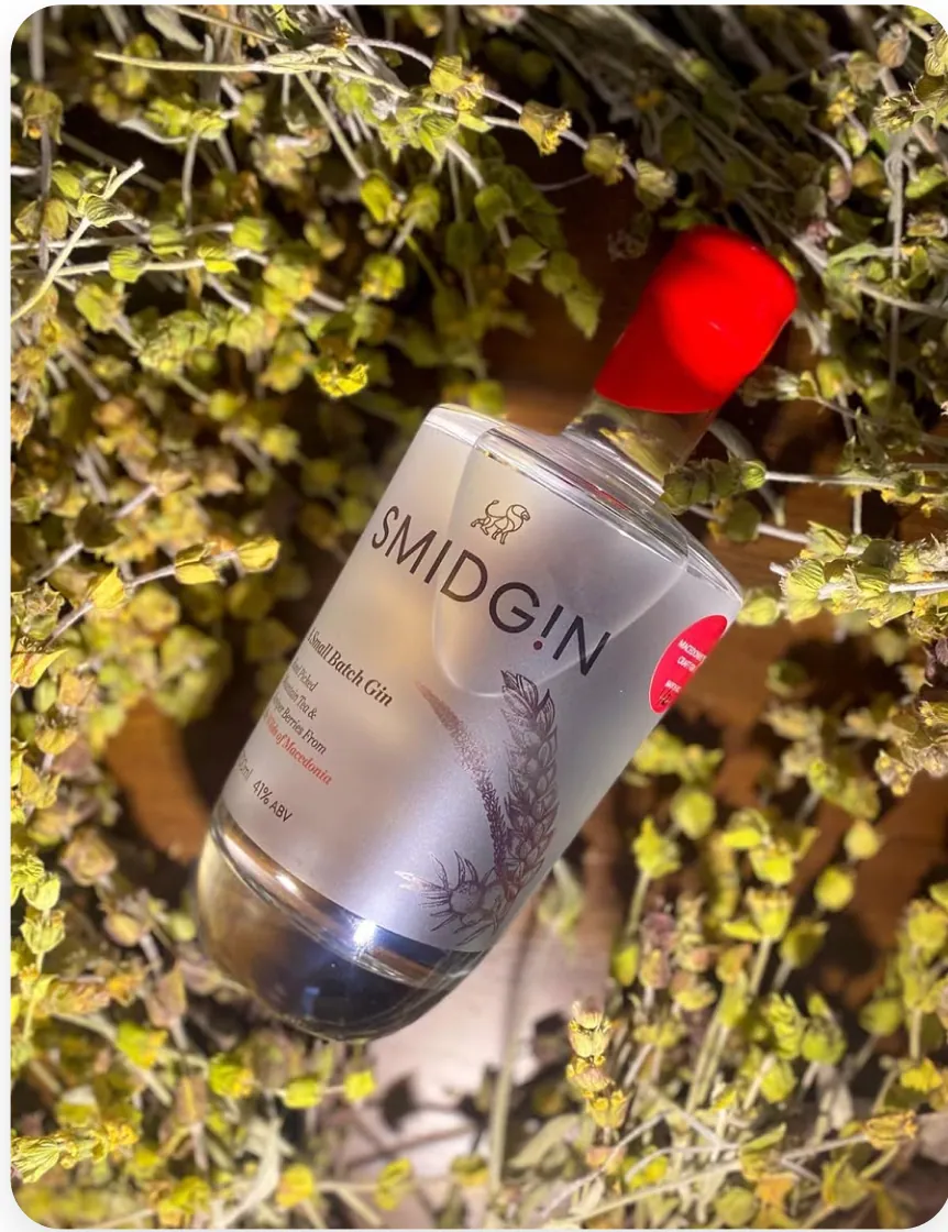 A bottle of Smidgin Classic lying among dried mountain botanicals